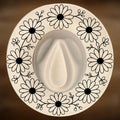 A circle of daisy designs on a wide brim hat.