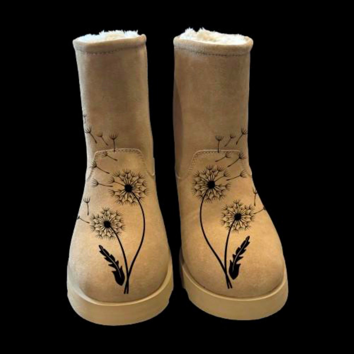A pair of boots with a boot burning design on them of dandelions.