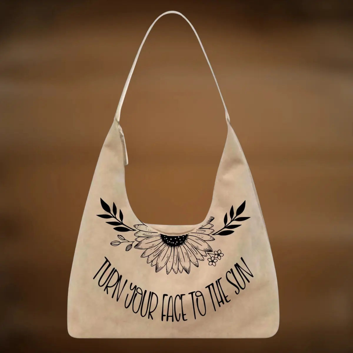Beige tote bag with black floral design and text on a brown background