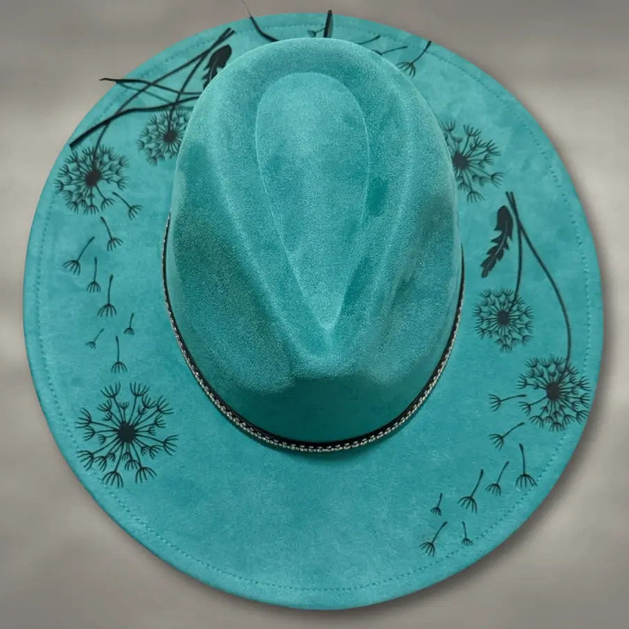 Turquoise cowboy hat with black floral designs on a gray background