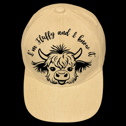 Baseball cap with a black highland cow illustration and text 'I'm Fluffy and I know it' on a black background