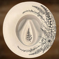 Wide brim hat with black floral and leaf designs on a brown background