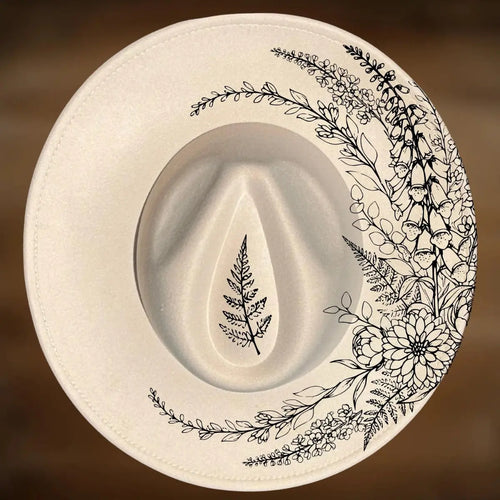 Wide brim hat with black floral and leaf designs on a brown background