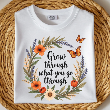 Grow Through What You Go Through PNG floral design with butterflies on a folded white t-shirt