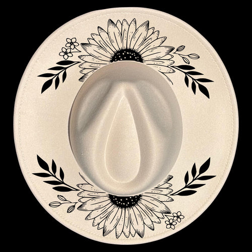 A wide brim hat with black floral and leaf patterns on a white background