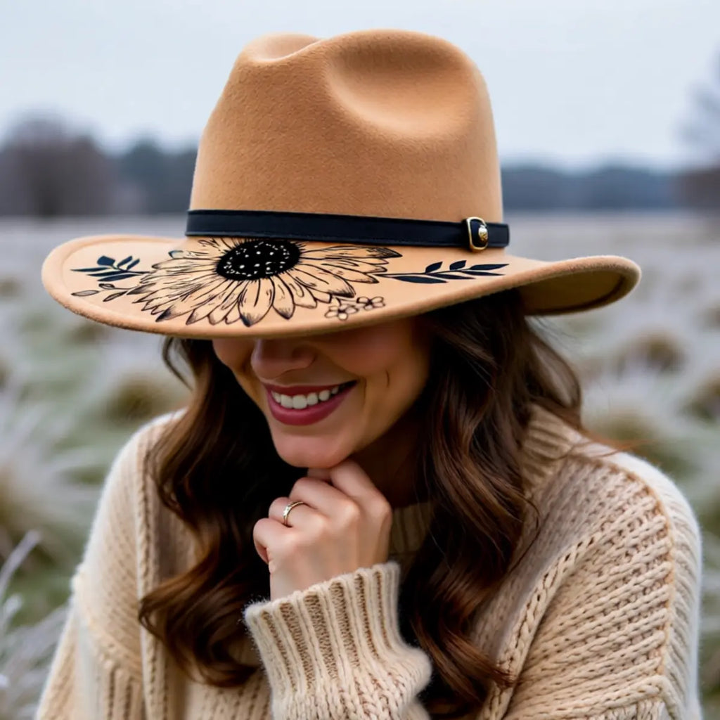 Woman wearing a tan hat with sunflower floral design outdoors