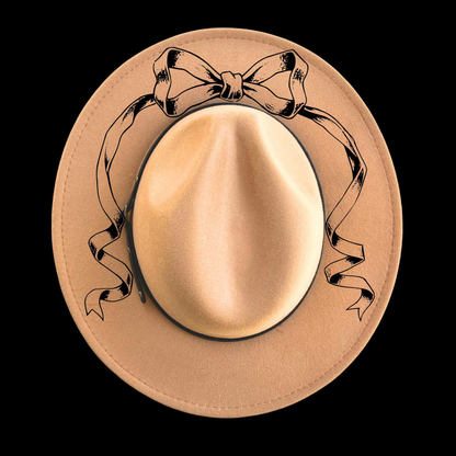 Narrow brim hat with decorative bow on a black background