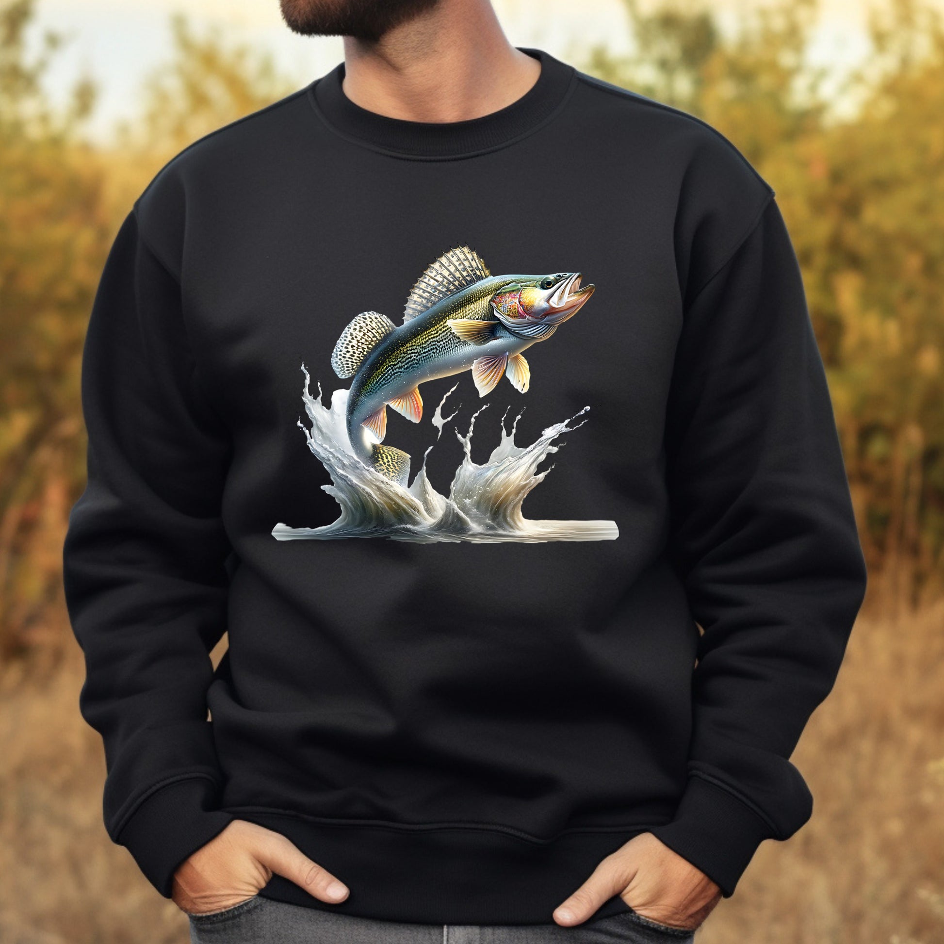 Black sweatshirt with a walleye fish graphic worn by a man, against a blurred natural background