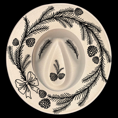 Decorative  pine wreath design of branches, bow, and pinecones on a wide brim hat