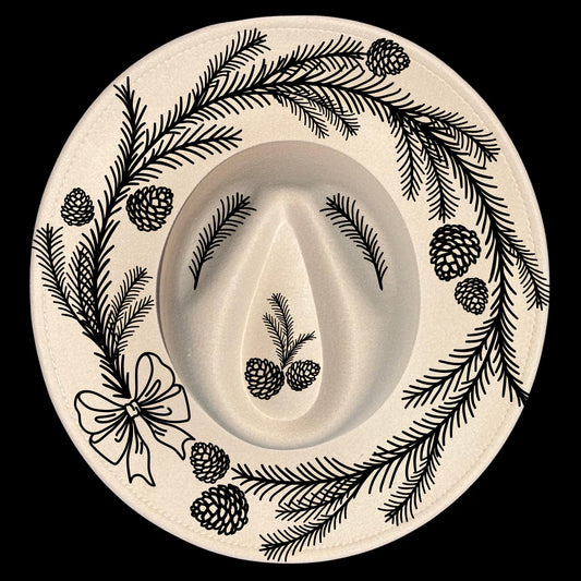 Decorative  pine wreath design of branches, bow, and pinecones on a wide brim hat