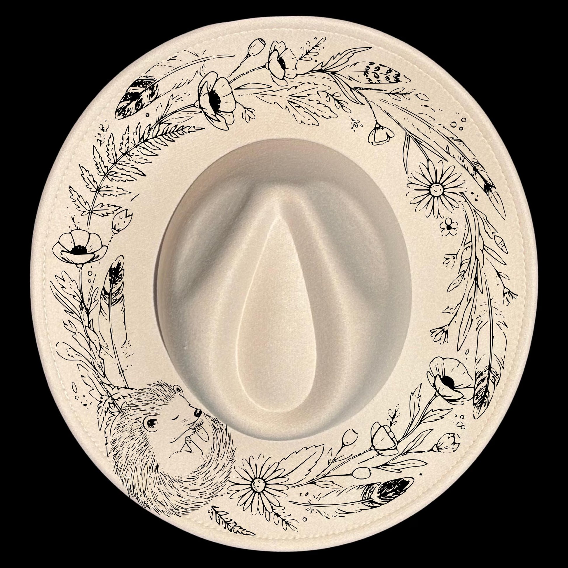 A sleeping hedgehog in a floral wreath shape for burning on wide brim hats