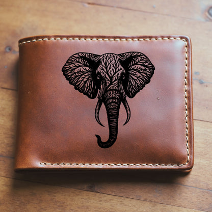Brown leather wallet with an elephant engraving sitting on a wooden surface