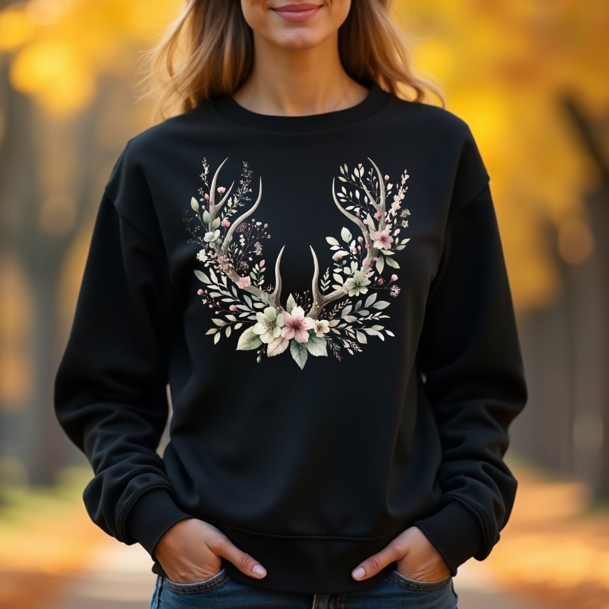 Woman wearing a black sweatshirt with floral antler design in an autumn setting