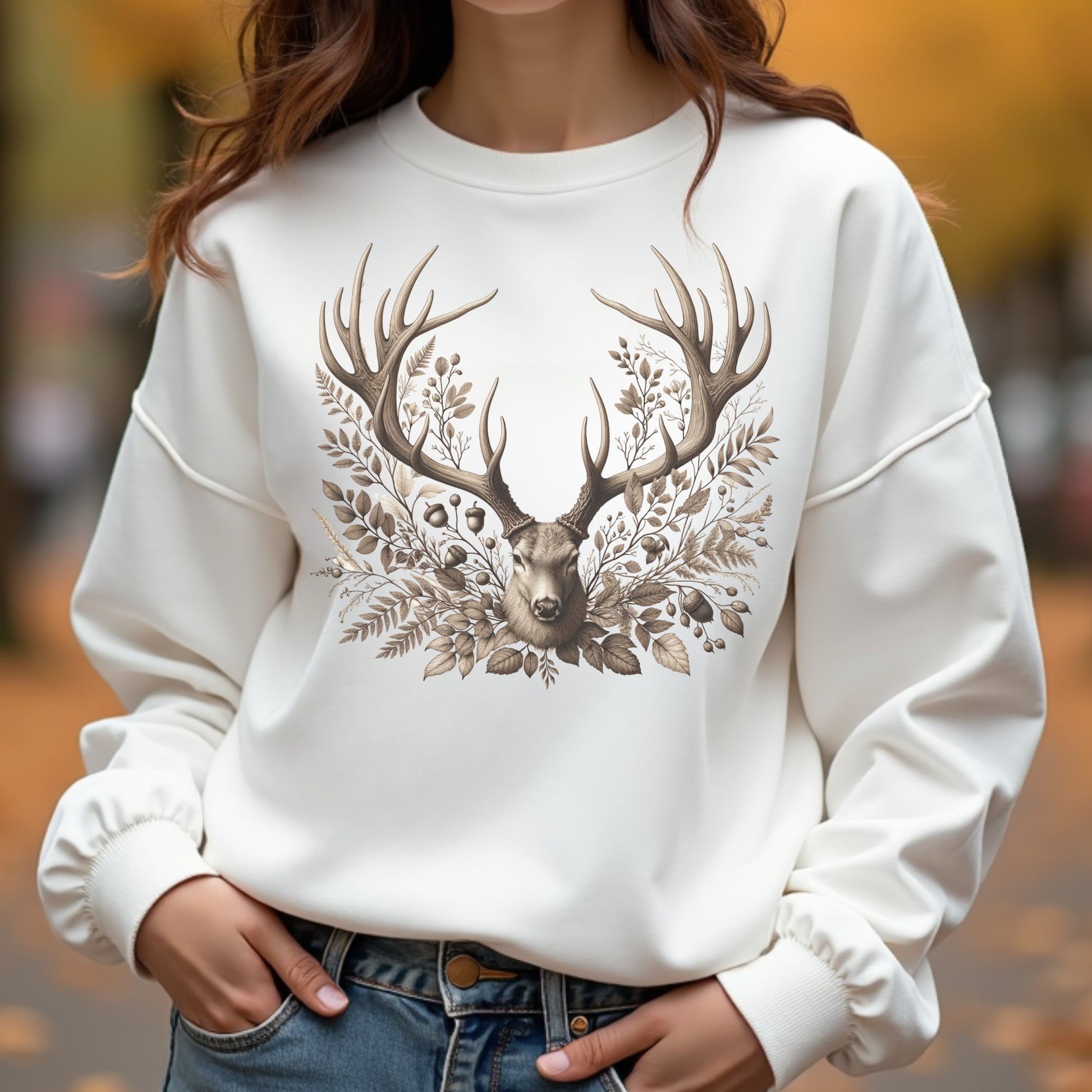 White sweatshirt with deer design worn by a woman outdoors